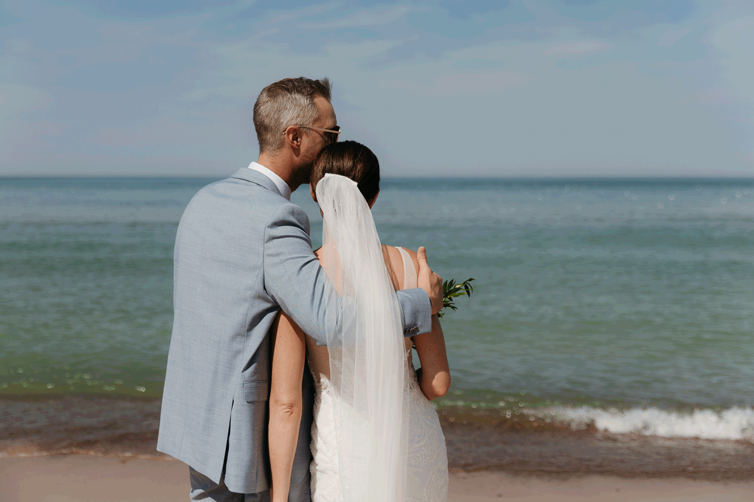 Bride and groom embracing and enjoying their Warren Dunes State Park elopement along the beach