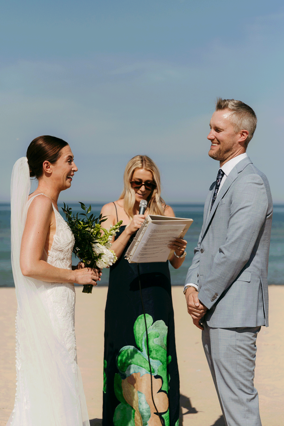 Bride and groom exchange vows on the beach during their Lake Michigan wedding ceremony at Warren Dunes State Park