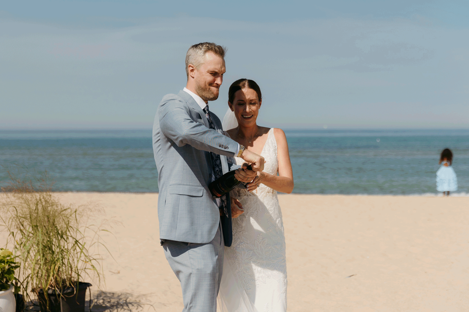 Bride and groom pop champagne for a toast with wedding guests at their Warren Dunes elopement