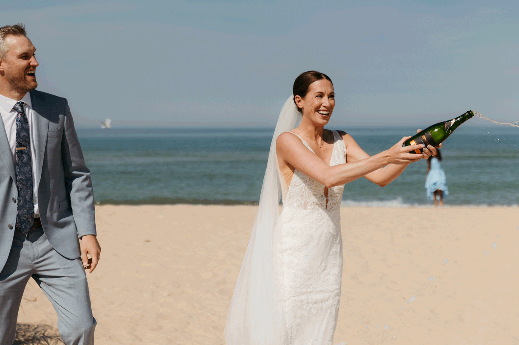 Bride and groom pop champagne for a toast with wedding guests at their Warren Dunes elopement