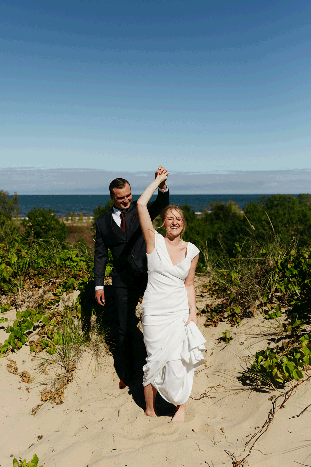 Bride and groom explore the dunes of Indiana Dunes National park during their intimate beach wedding