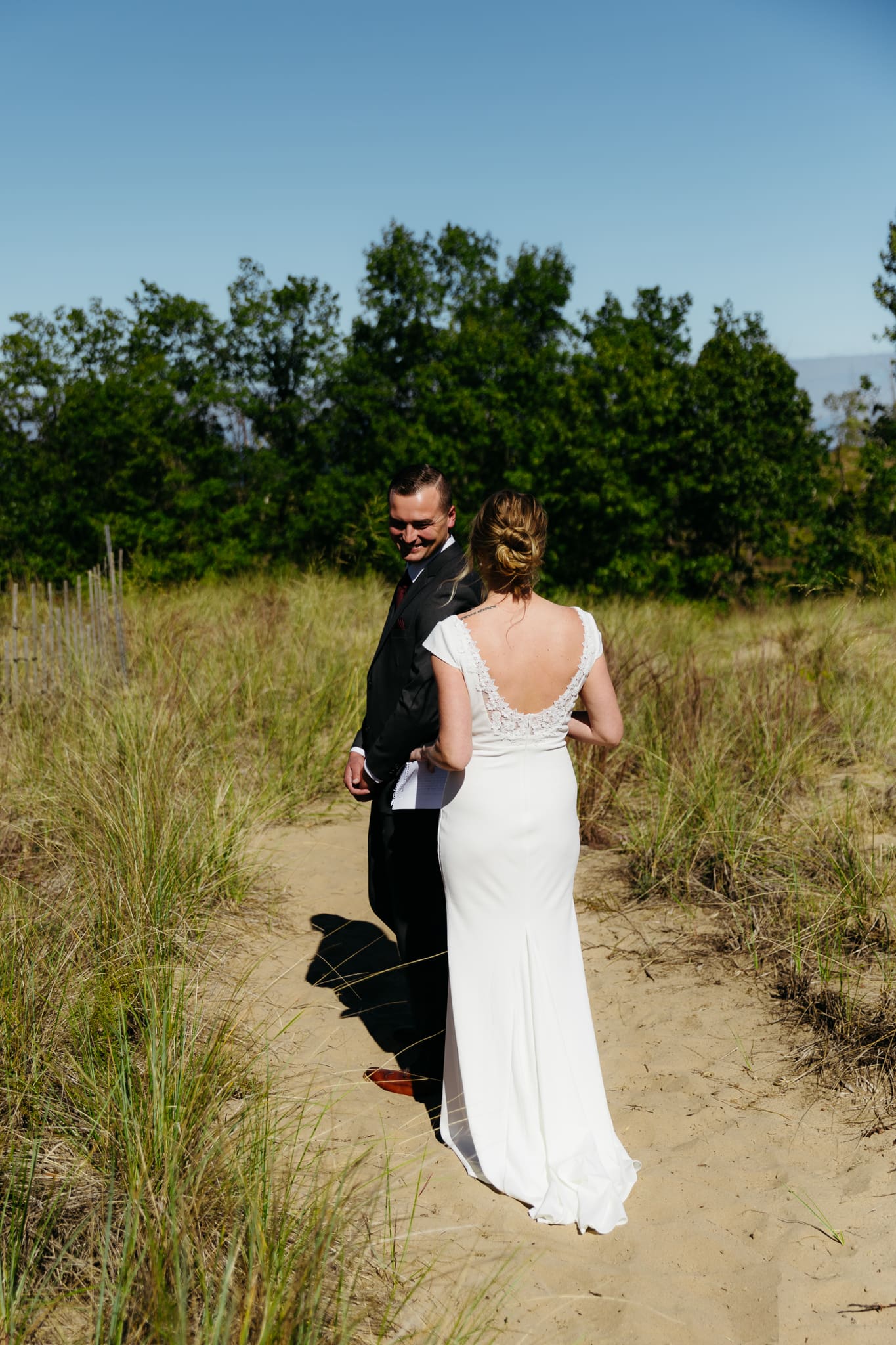 Bride and groom share a first look during their intimate wedding at Indiana Dunes National Park, amongst the sand dunes.