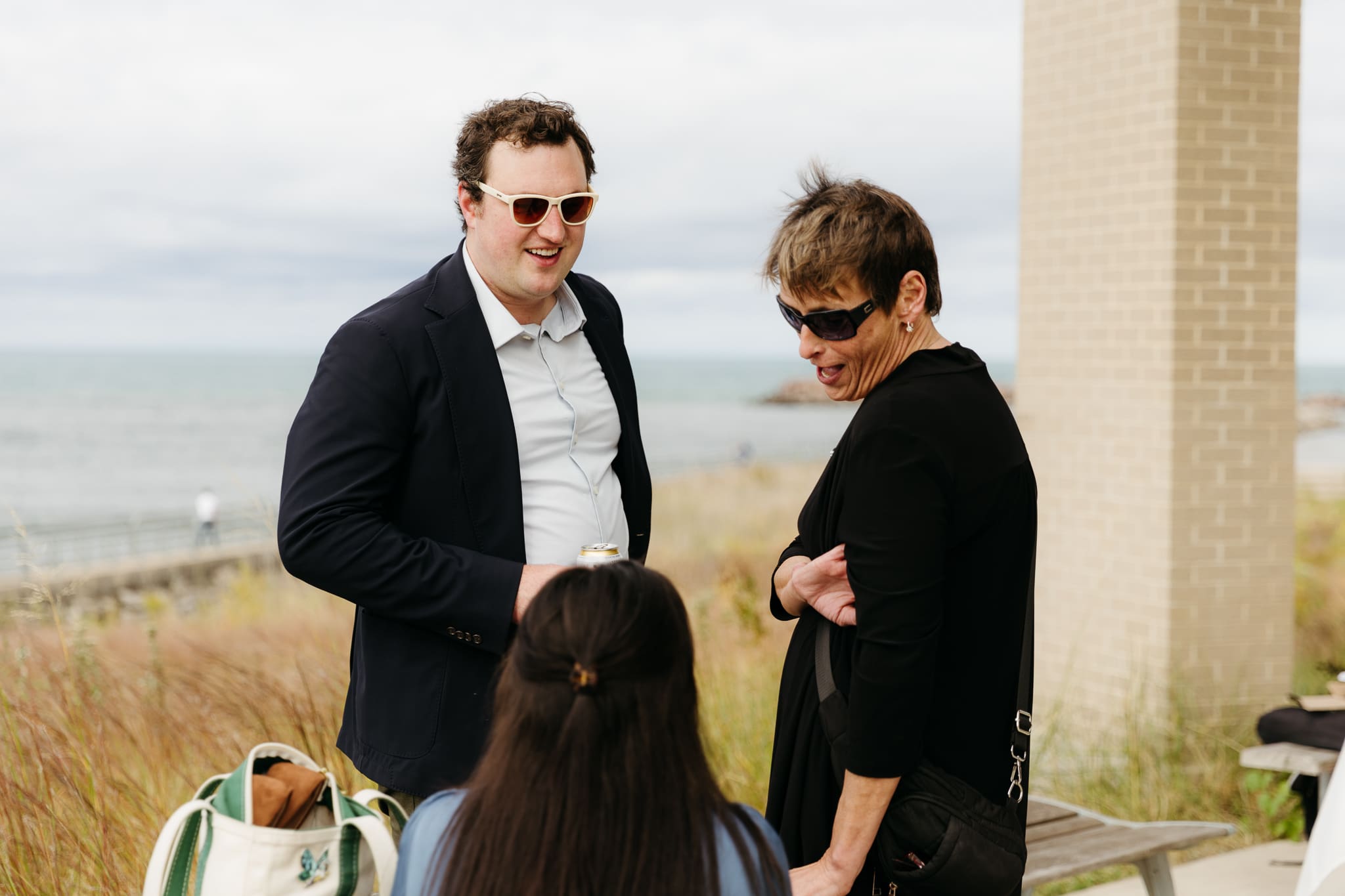 Bride and groom hanging out with family and friends during their outdoor wedding at Indiana Dunes National Park