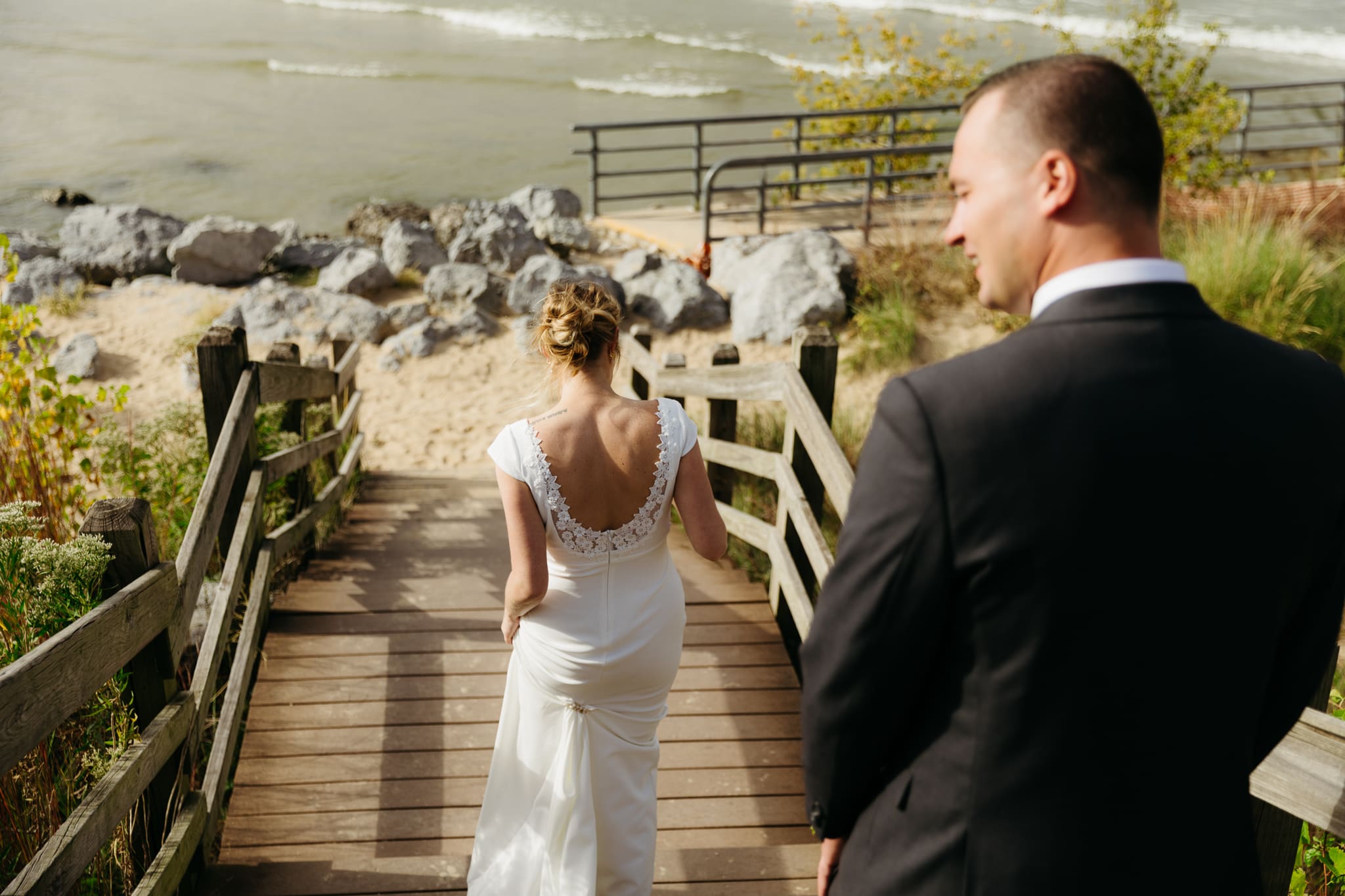 Bride and groom heading to the beach along Lake Michigan for couple portraits by the water