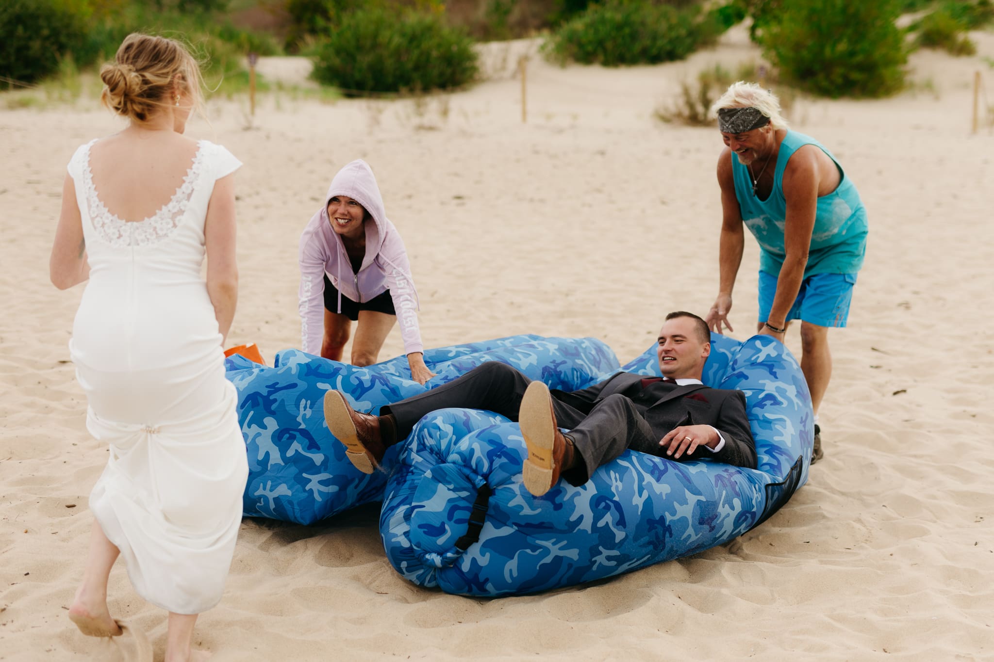 Bride and groom embrace and take couple portraits together along the beach of Lake Michigan during their Indiana Dunes National Park wedding.