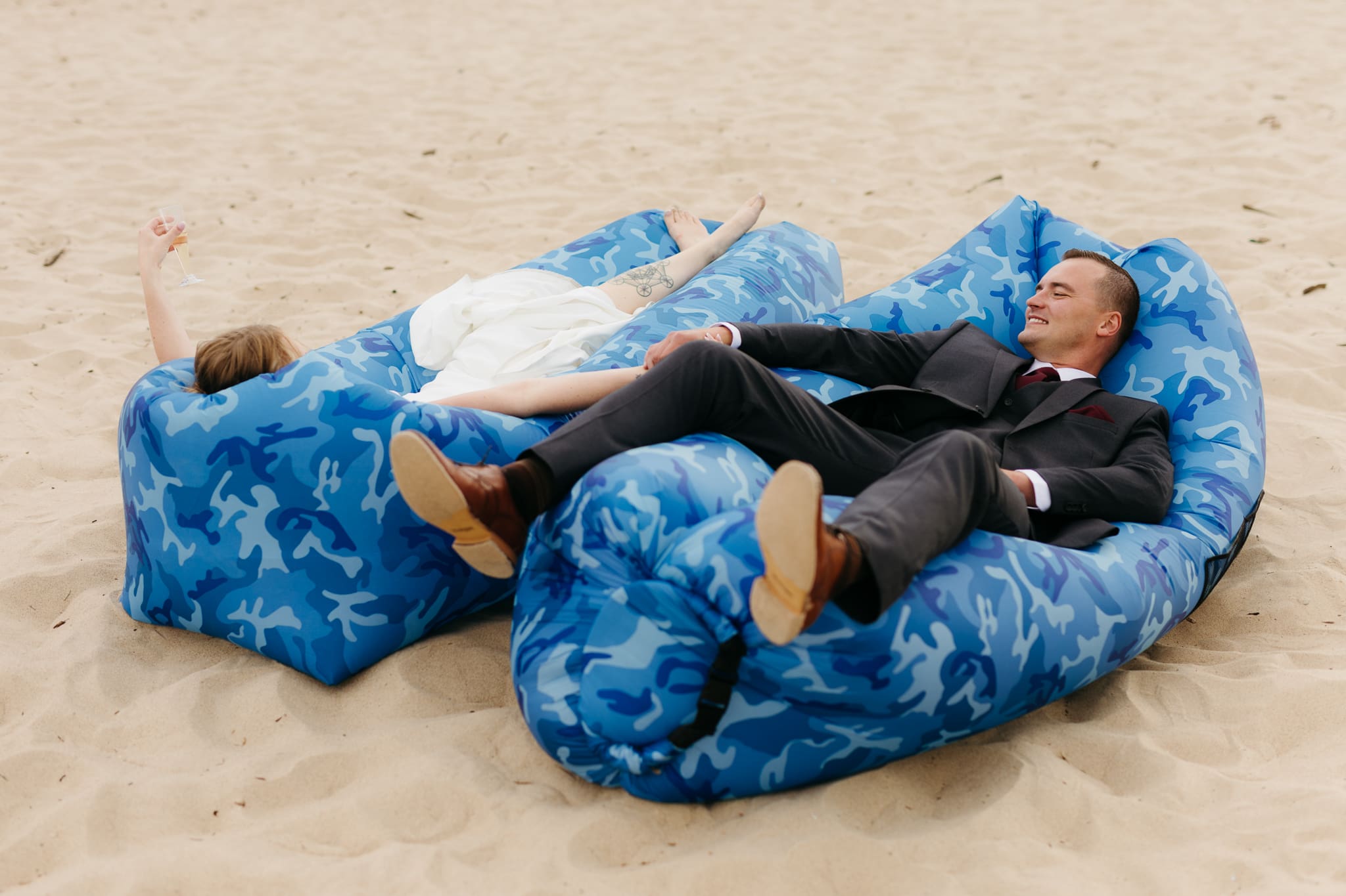 Bride and groom embrace and take couple portraits together along the beach of Lake Michigan during their Indiana Dunes National Park wedding.