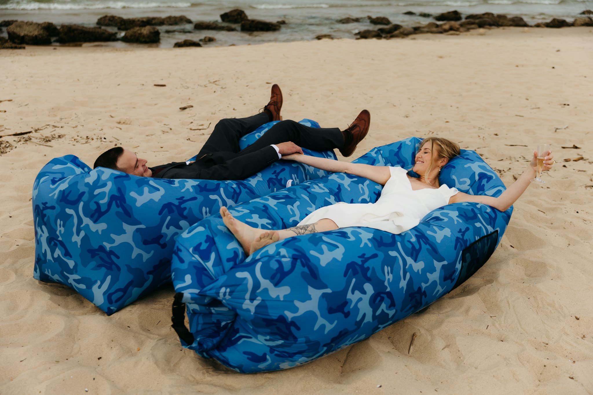 Bride and groom embrace and take couple portraits together along the beach of Lake Michigan during their Indiana Dunes National Park wedding.