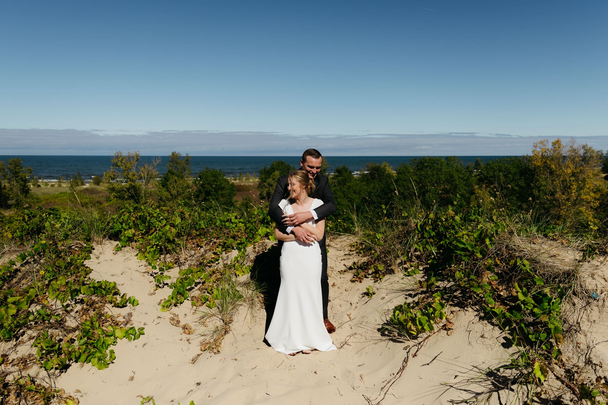 Bride and groom explore the dunes of Indiana Dunes National park during their intimate beach wedding