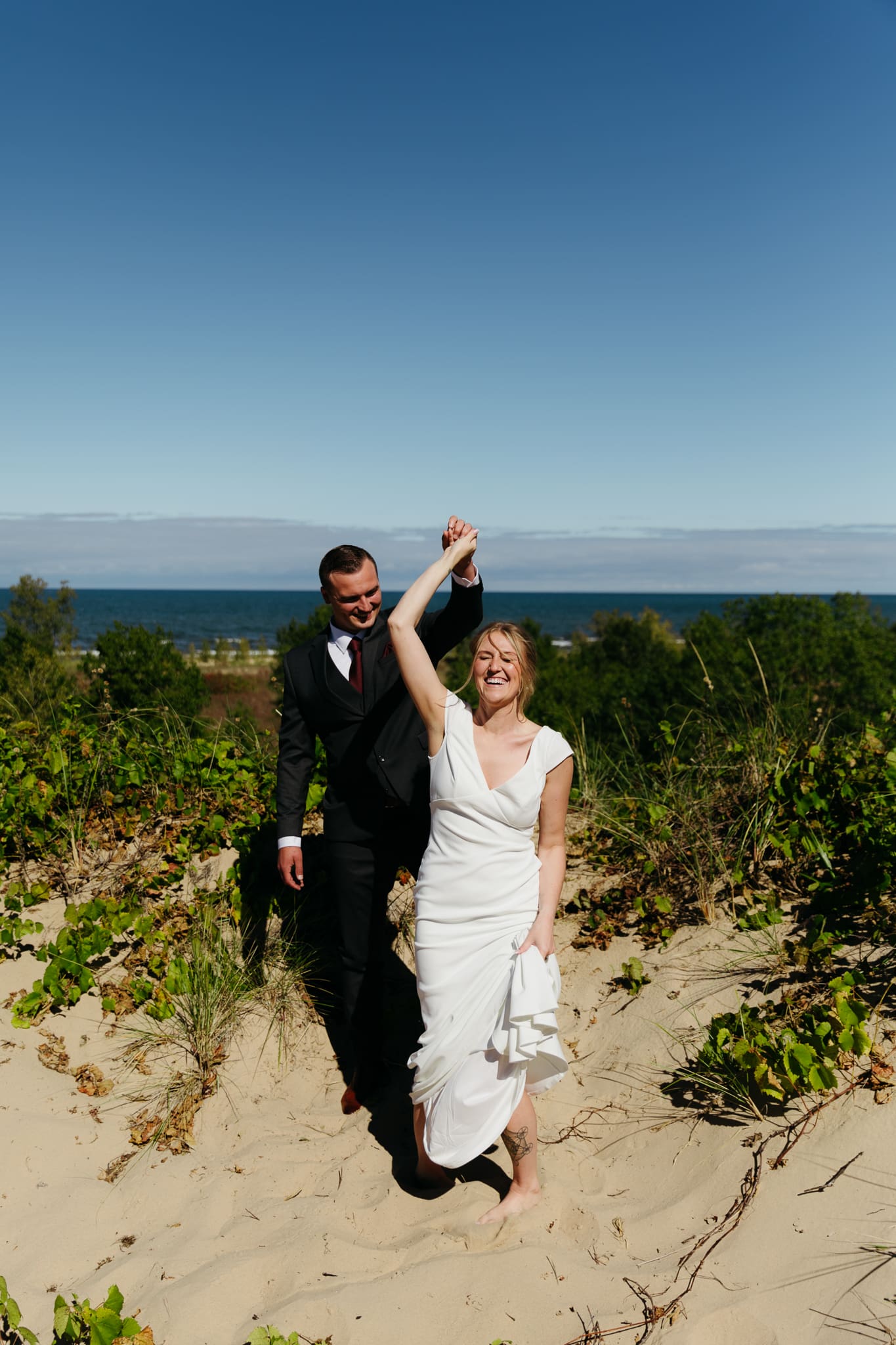 Bride and groom explore the dunes of Indiana Dunes National park during their intimate beach wedding
