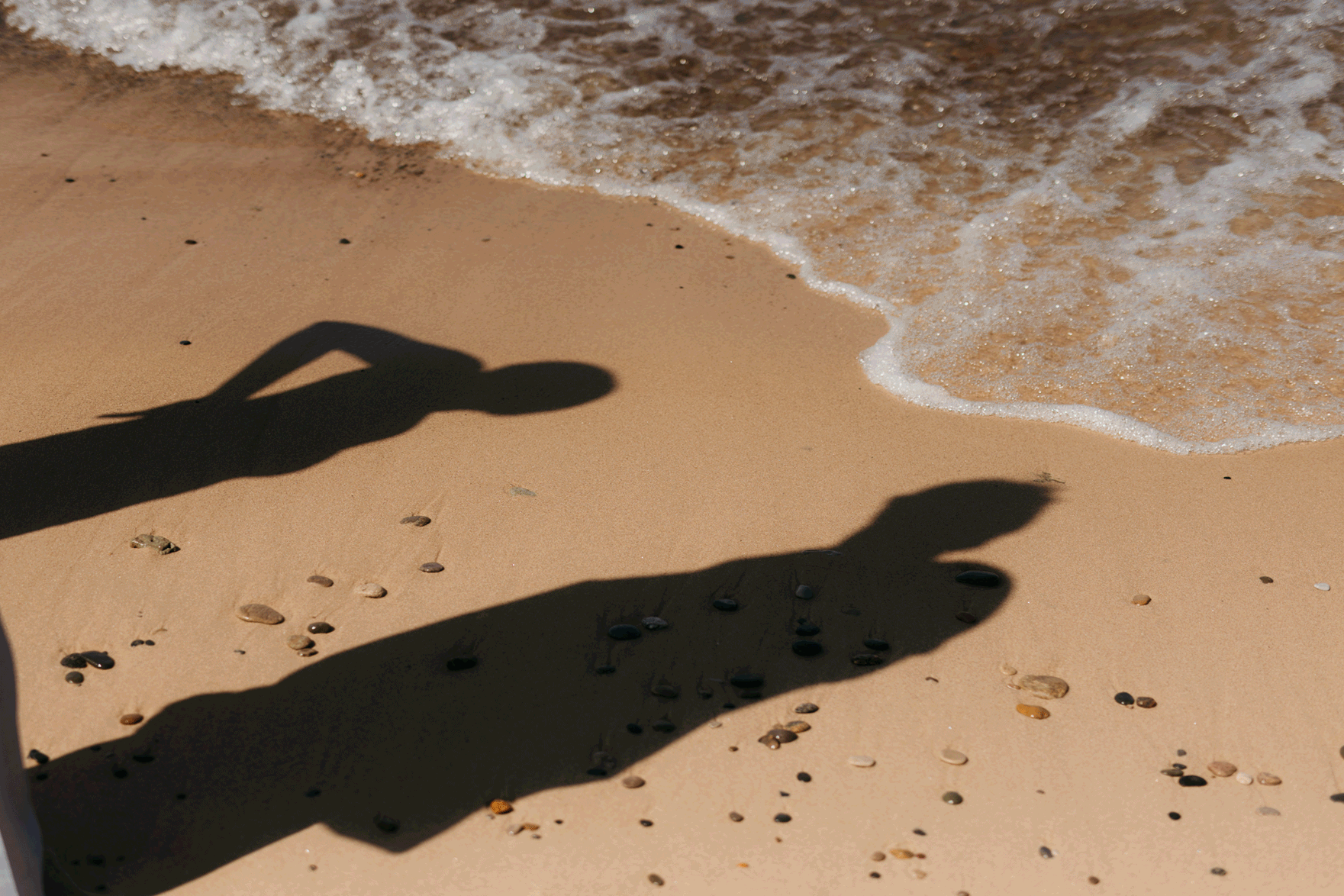 Bride and groom running along the shore of Lake Michigan during their elopement at Warren Dunes State Park
