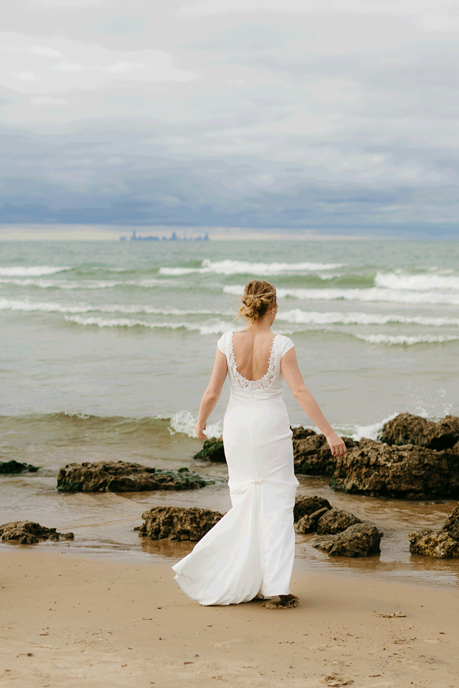 Bride and groom embrace and take couple portraits together along the beach of Lake Michigan during their Indiana Dunes National Park wedding.
